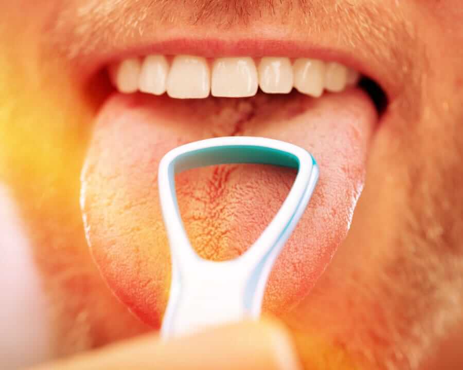 Man using a tongue scraper
