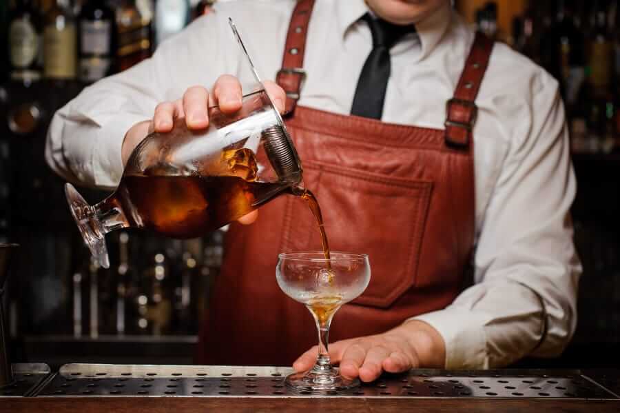 Bartender straining a cocktail
